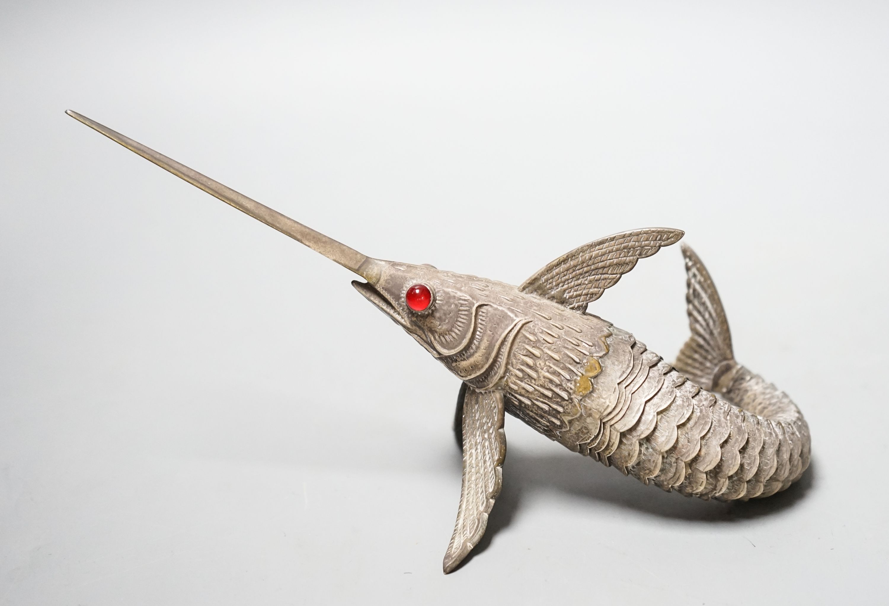 A 20th century Spanish articulated white metal model of a swordfish, with red glass eyes, approx. 26.5cm, gross weight 118 grams.